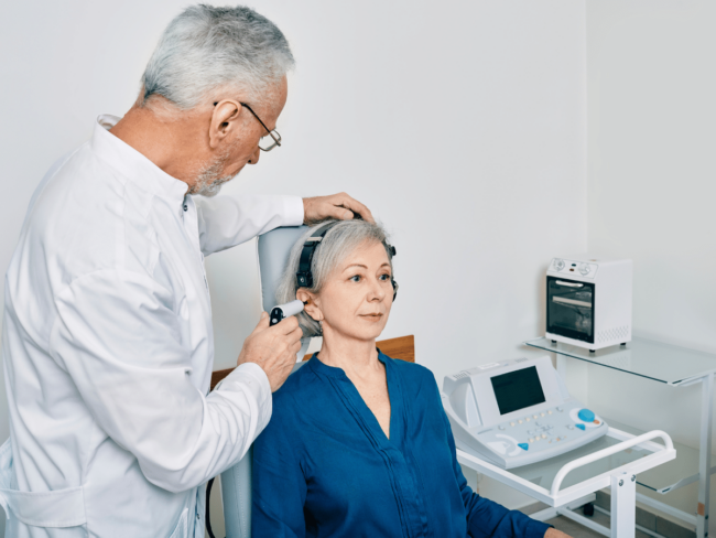 hearing health a senior woman being given an ear exam by an audiologist in preparation for hearing aids