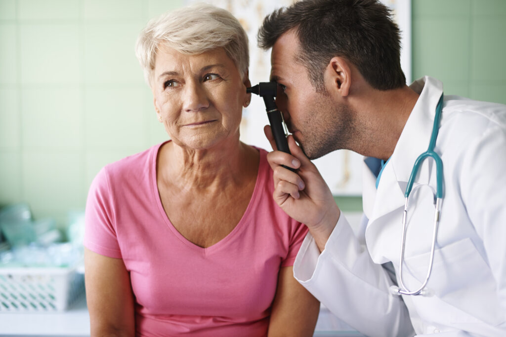 a doctor examining a senior woman's ear