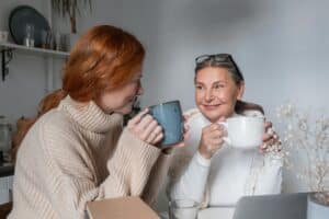 a mother and daughter having a chat over coffee or tea.