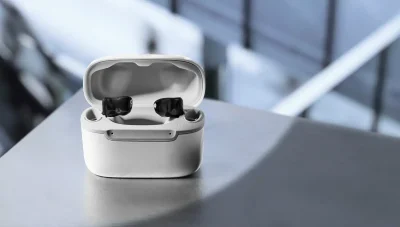 A pair of Signia Insio Charge&Go CIC IX hearing aids resting in their white charging case.